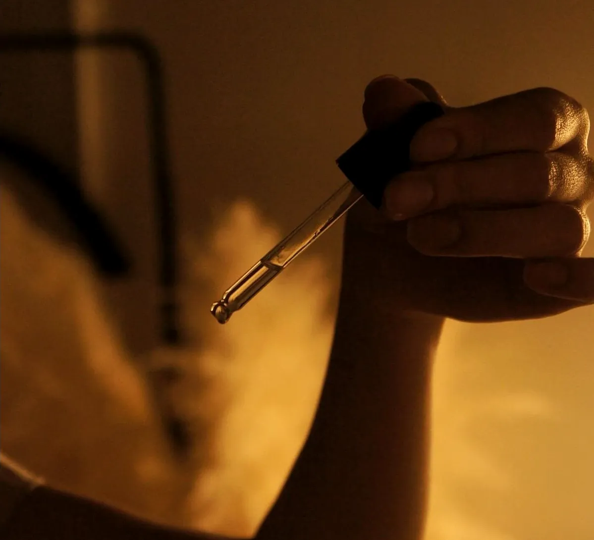 Facial serum from a glass dropper over an open palm, with warm steam, at Millán Spa in Miami Beach