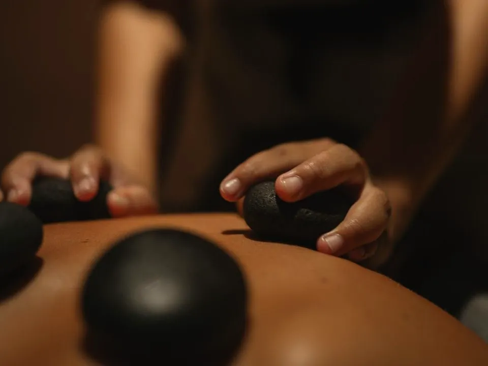 Close-up of a hot stone massage on a client's back at Millán Spa in Miami Beach