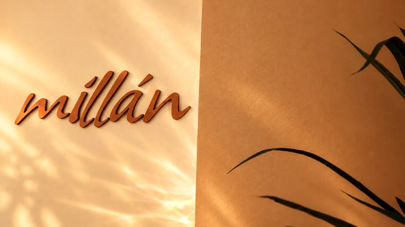 The Millán wordmark on a wall with palm leaves at Millán Spa, 960 Arthur Godfrey Rd, Miami Beach